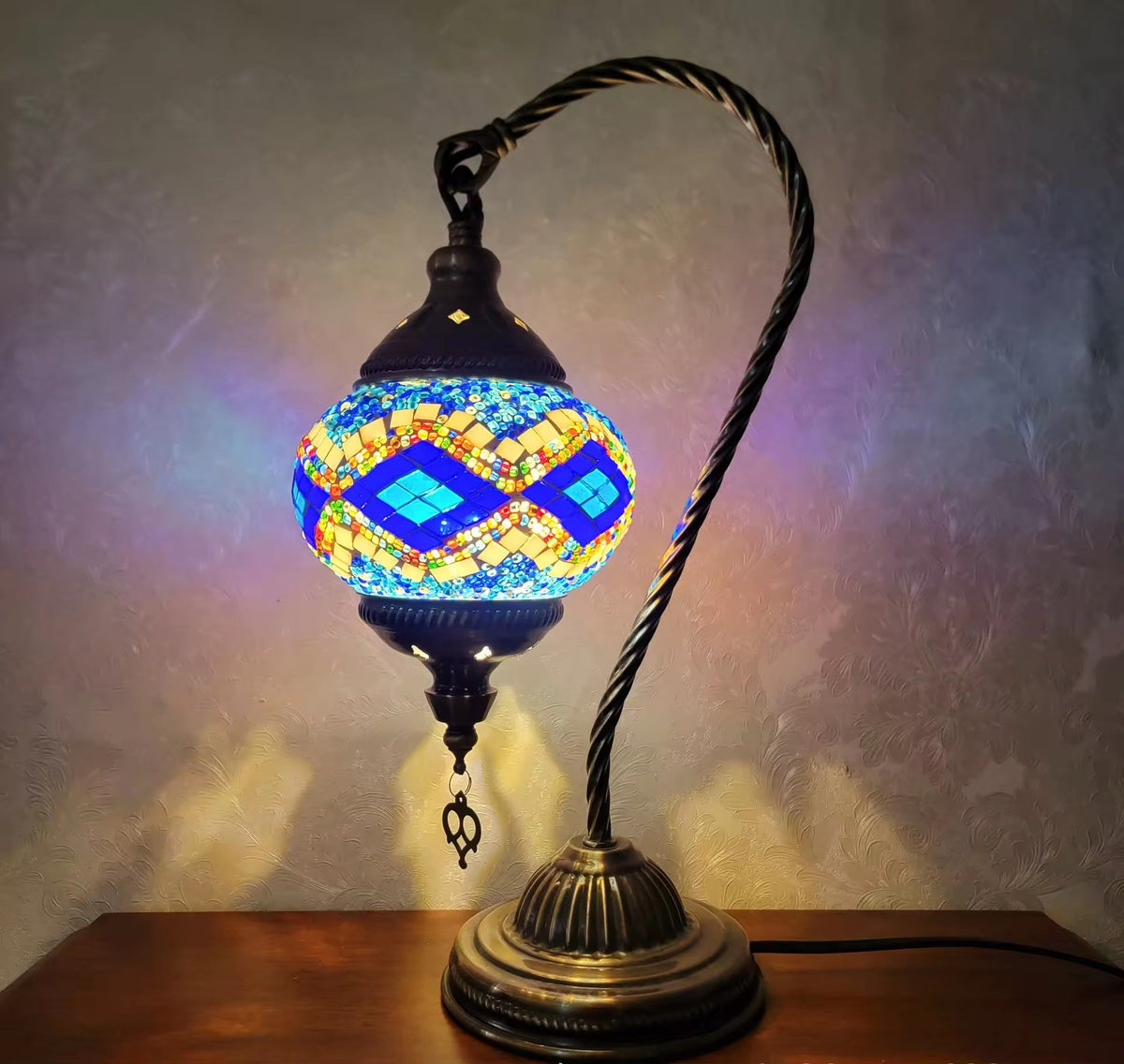 Swan-neck mosaic table lamp with a blue and gold glass globe, lit